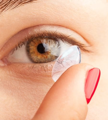 woman putting on contact lenses